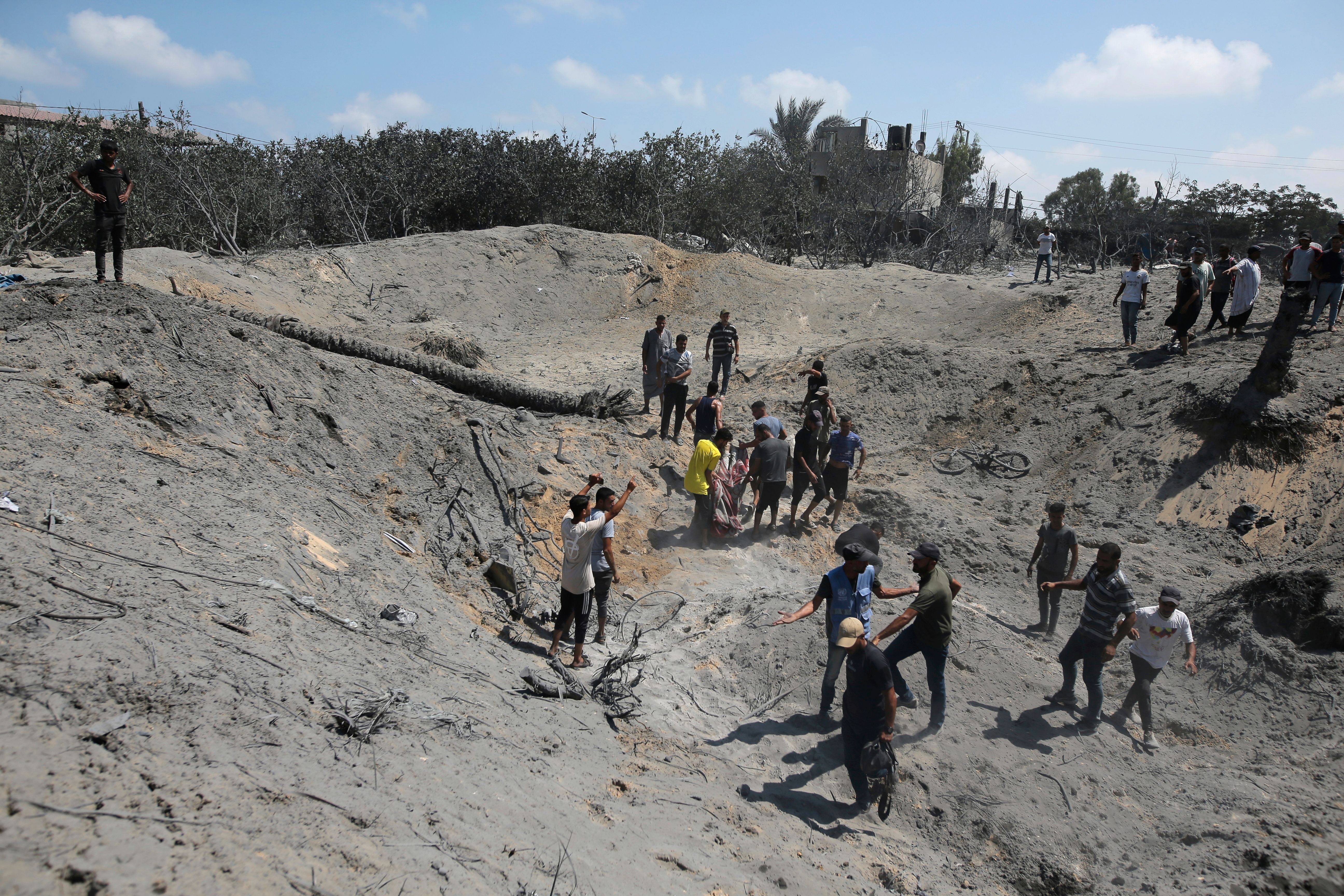 Palestinier letar efter överlevande efter attacken mot ett läger i al-Mawasi utanför staden Khan Yunis.