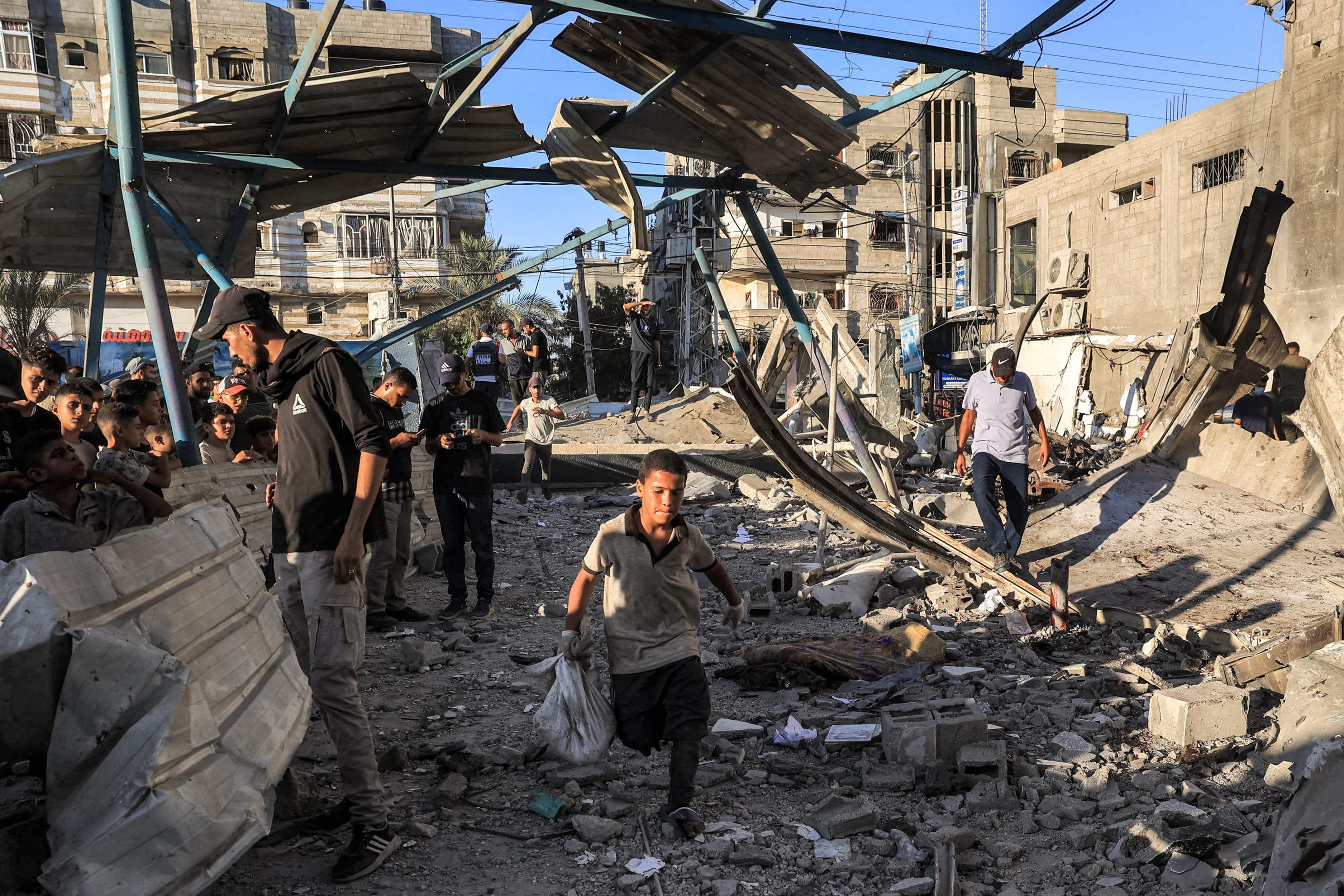En pojke springer längs förstörelsen efter en israelisk attack mot en skolbyggnad i Nuseirat den 6 juli.